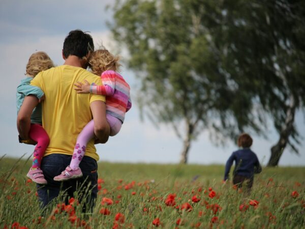 Man carrying children through flower fields